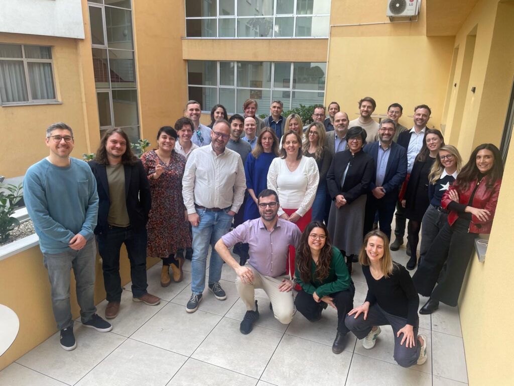 A group photo of the members of the consortium, posing together on the balcony.